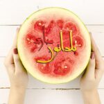 تصویر نمای بالا دست زن جوان و هندوانه شب یلدا