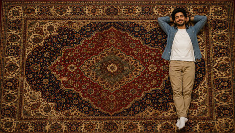 دانلود عکس تبلیغاتی مرد روی فرش ایرانی | تصویر باکیفیت مدل و قالی سنتی JPG